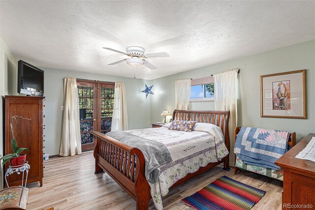 7622 E Nassau Ave, Denver, CO 80237 - bedroom with light wood-style flooring, multiple windows, access to exterior, a textured ceiling, and ceiling fan
