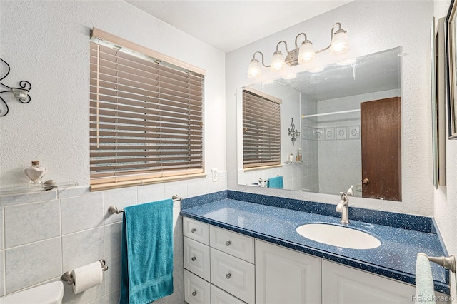 7622 E Nassau Ave, Denver, CO 80237 - full bath with vanity, tile walls, a shower, and a textured wall