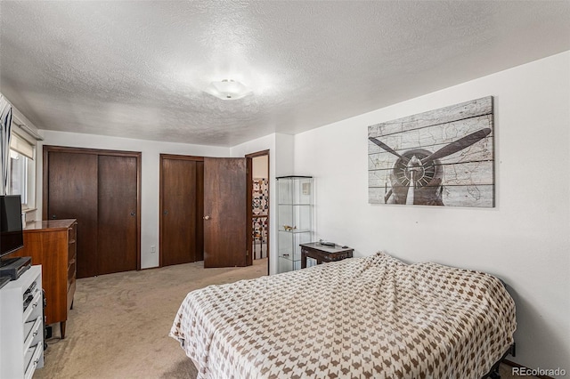 7622 E Nassau Ave, Denver, CO 80237 - bedroom with light colored carpet, two closets, and a textured ceiling