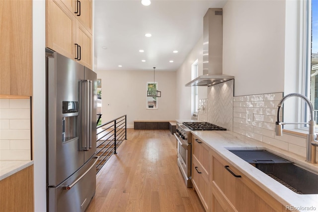 459 N Clarkson St, Denver, CO 80218 - kitchen featuring premium appliances, wall chimney exhaust hood, recessed lighting, light brown cabinets, and light stone countertops