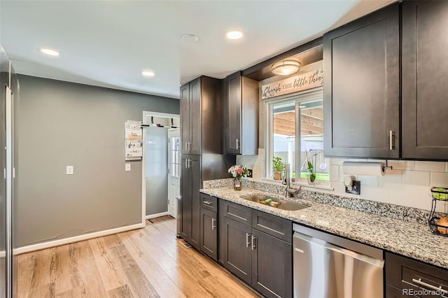 3180 Mowry Pl, Westminster, CO 80031 - kitchen featuring stainless steel dishwasher, a sink, light wood-style floors, and light stone counters