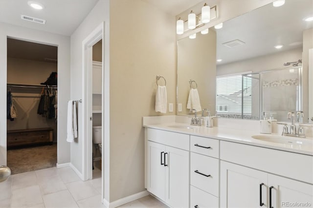 9807 Rosalee Peak St, Littleton, CO 80125 - full bath with double vanity, a stall shower, toilet, a walk in closet, and recessed lighting