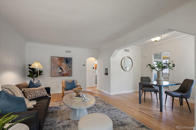 1439 Dexter St, Denver, CO 80220 - living room with arched walkways, light wood-type flooring, baseboards, and ornamental molding