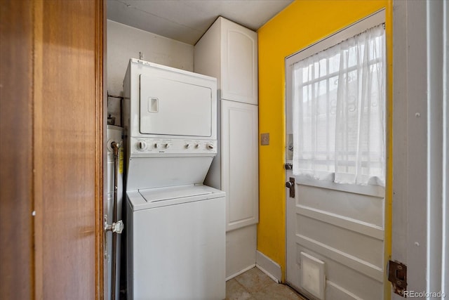 1439 Dexter St, Denver, CO 80220 - laundry area with stacked washing machine and dryer, cabinet space, and baseboards