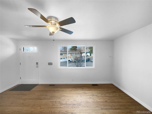 entryway with dark wood-type flooring and ceiling fan