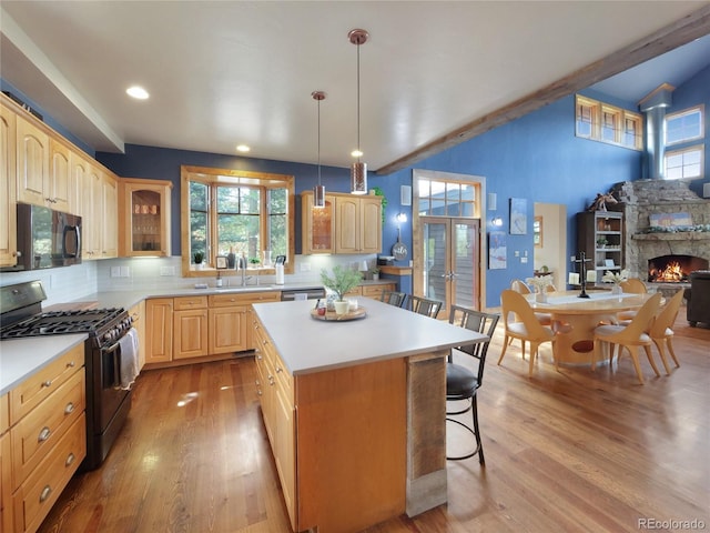 77 B Rd, Silverthorne, CO 80498 - kitchen featuring gas stove, black microwave, a kitchen bar, light brown cabinets, and backsplash