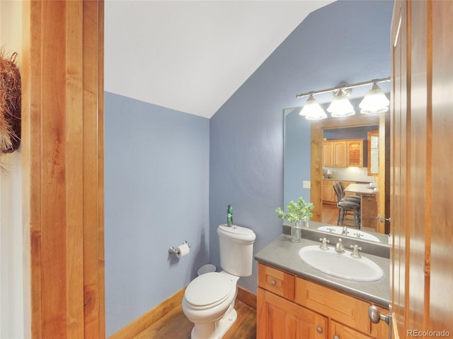 77 B Rd, Silverthorne, CO 80498 - half bathroom featuring lofted ceiling, toilet, vanity, and wood finished floors