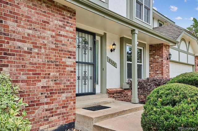 8182 Sweet Water Rd, Lone Tree, CO 80124 - entrance to property featuring a shingled roof, brick siding, stucco siding, and an attached garage