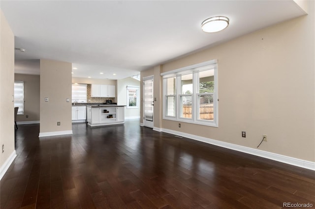 8182 Sweet Water Rd, Lone Tree, CO 80124 - unfurnished living room featuring baseboards, dark wood-type flooring, a sink, and recessed lighting