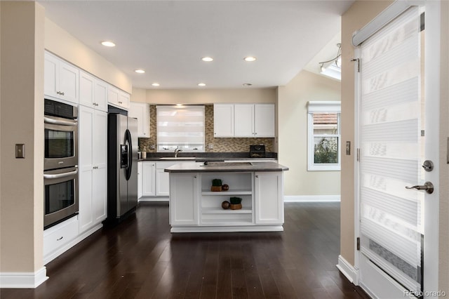 8182 Sweet Water Rd, Lone Tree, CO 80124 - kitchen featuring appliances with stainless steel finishes, dark countertops, open shelves, white cabinets, and healthy amount of natural light