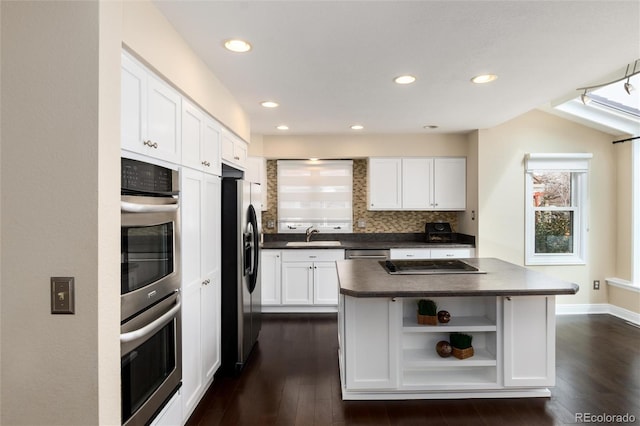 8182 Sweet Water Rd, Lone Tree, CO 80124 - kitchen with appliances with stainless steel finishes, dark countertops, open shelves, a kitchen island, and white cabinets