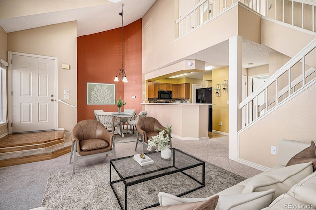 living room featuring high vaulted ceiling, carpet floors, and a chandelier