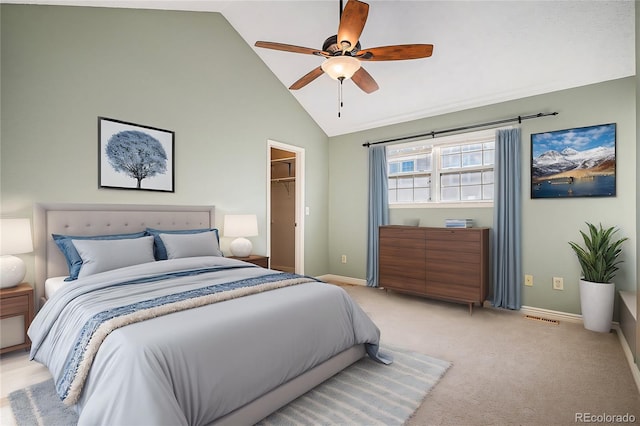 bedroom featuring ceiling fan, high vaulted ceiling, light carpet, a walk in closet, and a closet