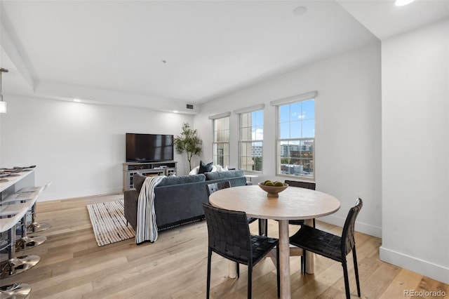 dining area with baseboards and light wood-style floors