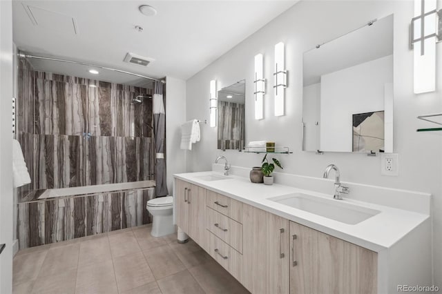 bathroom featuring toilet, visible vents, a sink, and shower / bath combo with shower curtain