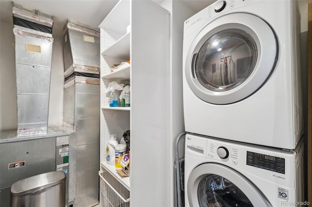 laundry room with laundry area, stacked washing maching and dryer, and heating unit