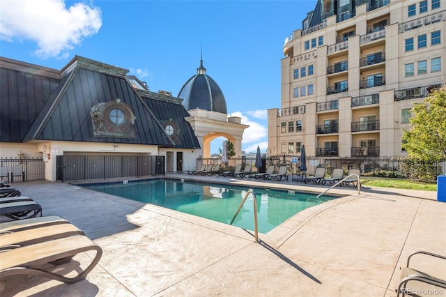 community pool featuring a patio area and fence