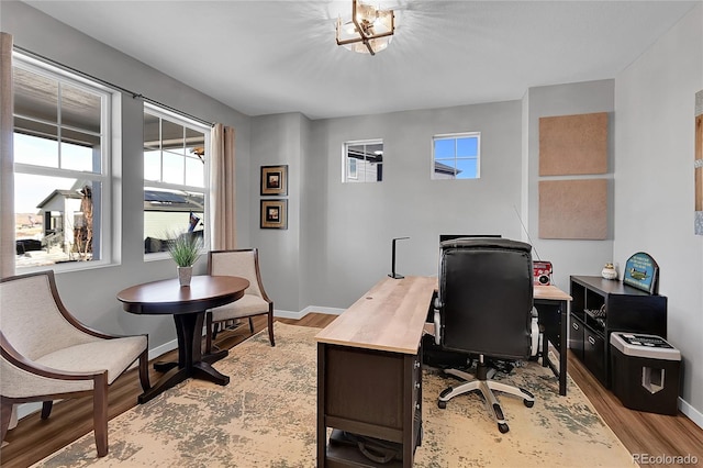 home office with light hardwood / wood-style flooring