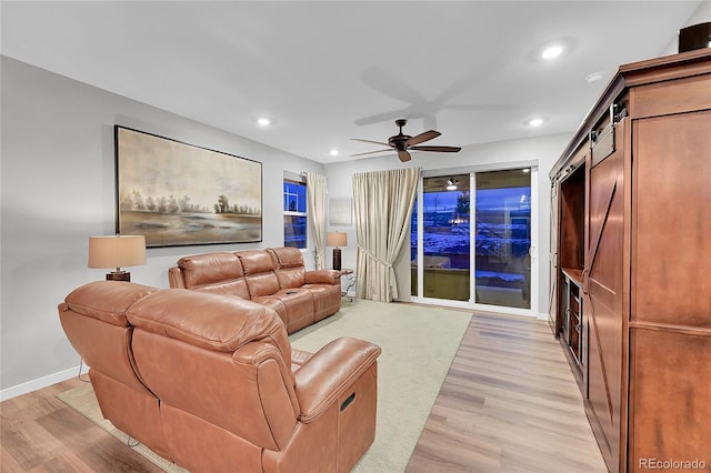 living room with light hardwood / wood-style floors and ceiling fan