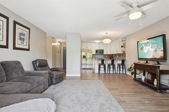 3465 S Poplar St Unit 305, Denver, CO 80224 - living room with light wood-type flooring, a ceiling fan, and baseboards