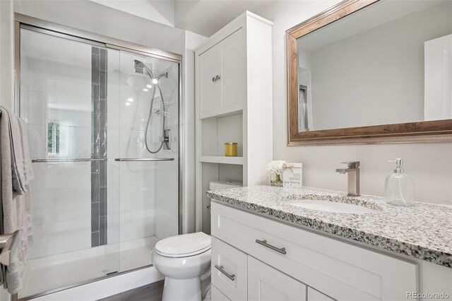 3465 S Poplar St Unit 305, Denver, CO 80224 - bathroom featuring a shower stall, toilet, and vanity