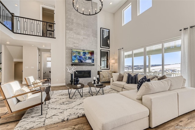 living room featuring a wealth of natural light, light wood-type flooring, and a high ceiling