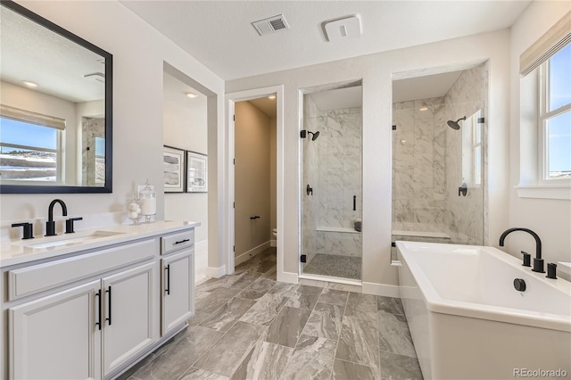 full bathroom with vanity, toilet, a textured ceiling, and independent shower and bath