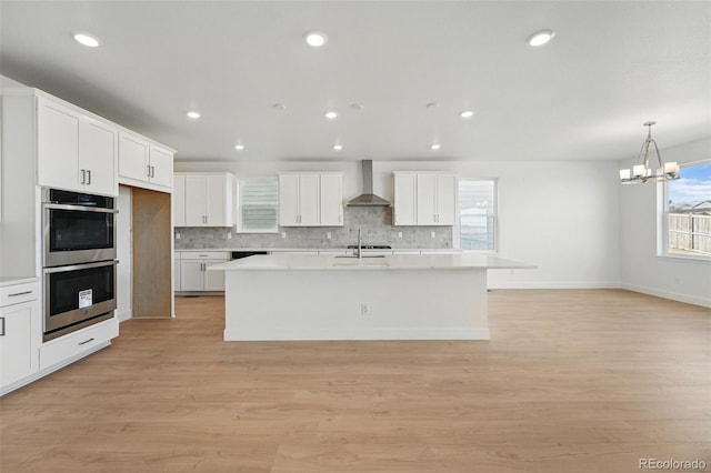 16537 Black Rose Cir, Parker, CO 80134 - kitchen featuring wall chimney range hood, double oven, tasteful backsplash, and light countertops
