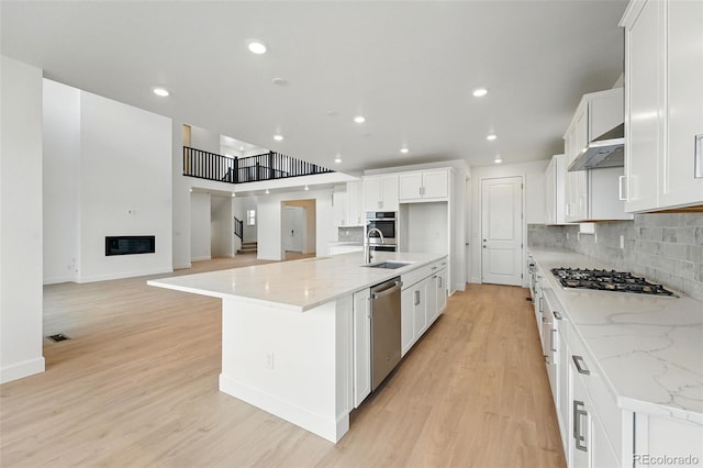 16537 Black Rose Cir, Parker, CO 80134 - kitchen with light wood finished floors, backsplash, a sink, and stainless steel appliances