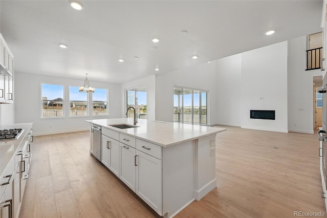 16537 Black Rose Cir, Parker, CO 80134 - kitchen with a chandelier, light wood finished floors, appliances with stainless steel finishes, white cabinetry, and a sink