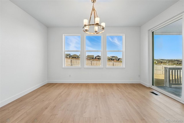 16537 Black Rose Cir, Parker, CO 80134 - unfurnished room with light wood finished floors, baseboards, visible vents, and a chandelier