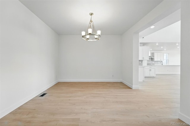 16537 Black Rose Cir, Parker, CO 80134 - spare room featuring baseboards, visible vents, a notable chandelier, and light wood-type flooring