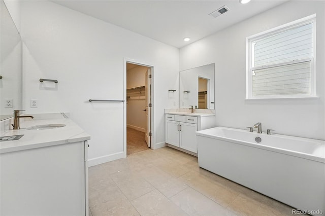 16537 Black Rose Cir, Parker, CO 80134 - full bathroom featuring baseboards, a sink, visible vents, a freestanding bath, and two vanities