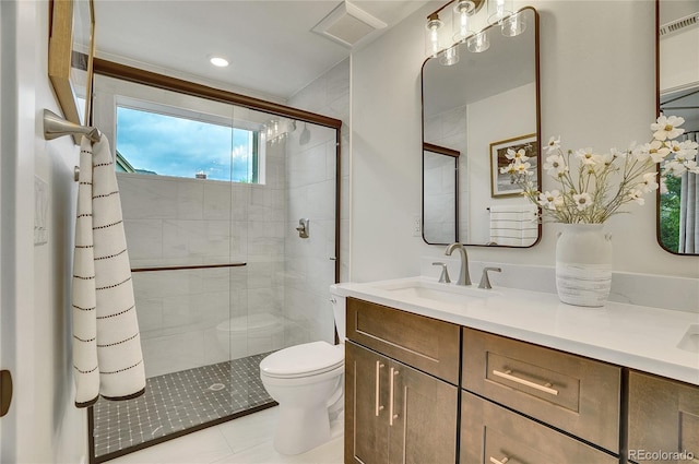 bathroom with an enclosed shower, tile flooring, toilet, and vanity with extensive cabinet space