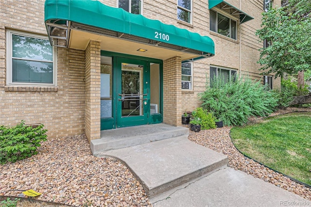 view of exterior entry featuring brick siding