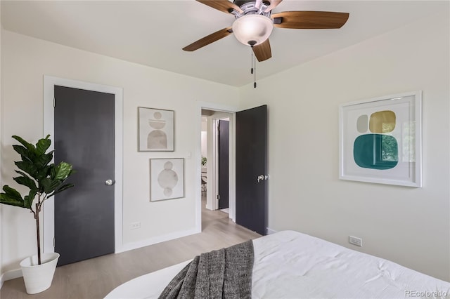 bedroom featuring baseboards, light wood-style floors, and a ceiling fan