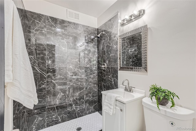 full bath featuring visible vents, tiled shower, toilet, and vanity