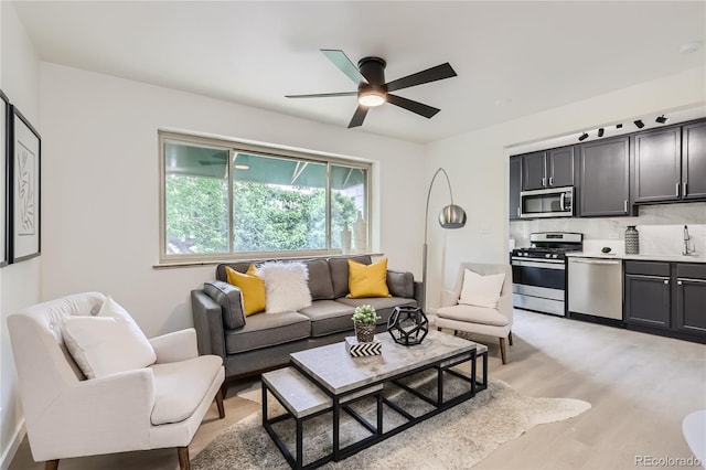 living area with light wood-style flooring and ceiling fan