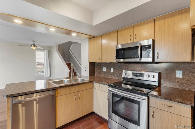 kitchen featuring light brown cabinets, ceiling fan, appliances with stainless steel finishes, dark hardwood / wood-style flooring, and kitchen peninsula