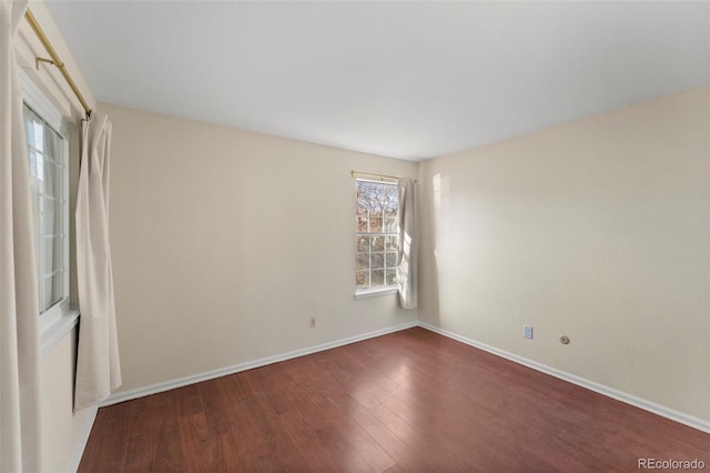 empty room with dark hardwood / wood-style flooring