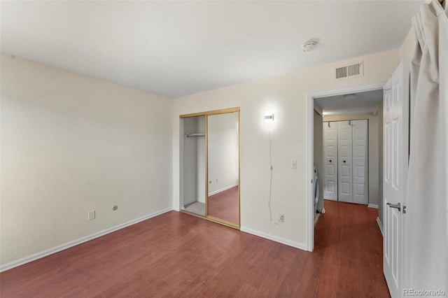 unfurnished bedroom with dark wood-type flooring