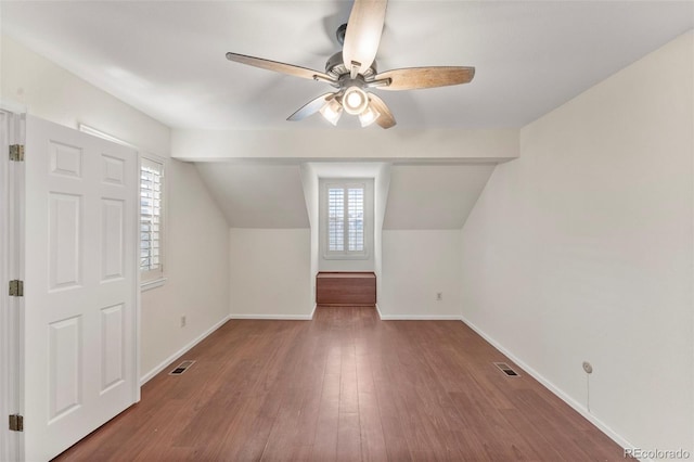 additional living space featuring hardwood / wood-style flooring, vaulted ceiling, ceiling fan, and a healthy amount of sunlight