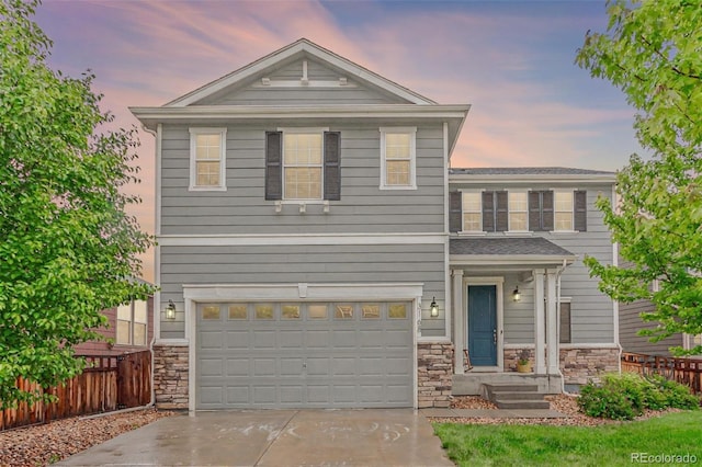 3168 Raintree Ln, Dacono, CO 80514 - view of front of house with stone siding, an attached garage, and concrete driveway