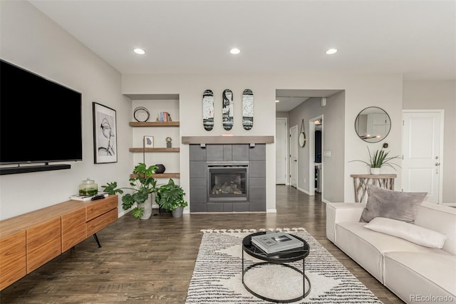 3168 Raintree Ln, Dacono, CO 80514 - living room featuring dark wood-style floors, a fireplace, built in shelves, and recessed lighting