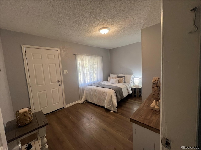 bedroom featuring dark wood-type flooring and a textured ceiling