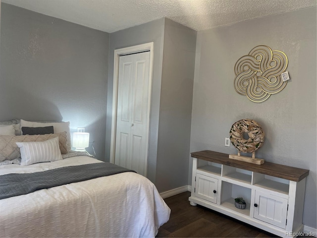 bedroom featuring a closet, dark wood-type flooring, and a textured ceiling