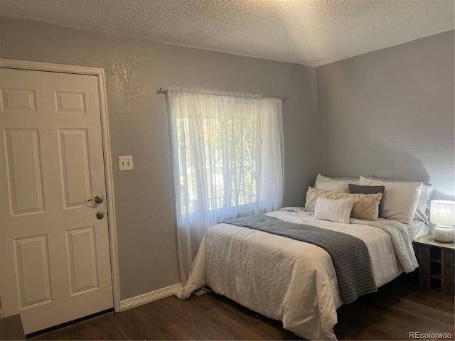 bedroom featuring dark wood-type flooring and a textured ceiling