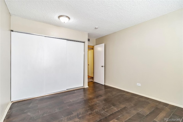 unfurnished bedroom with dark hardwood / wood-style flooring, a closet, and a textured ceiling