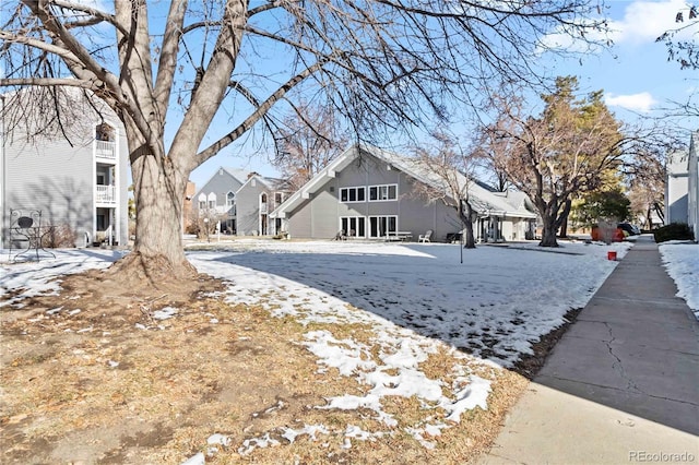 snowy yard featuring a residential view