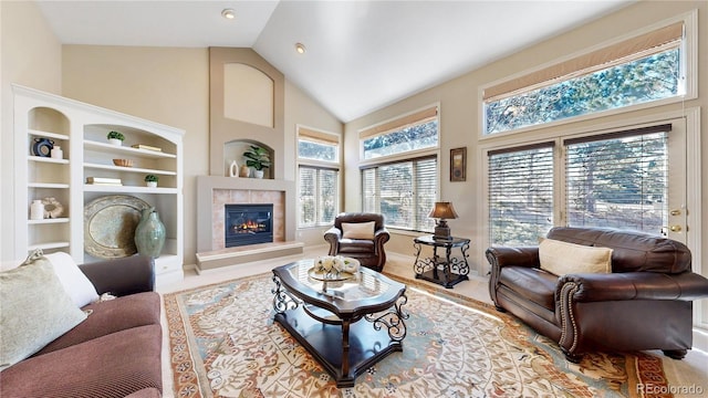 living area featuring high vaulted ceiling, built in shelves, and a fireplace